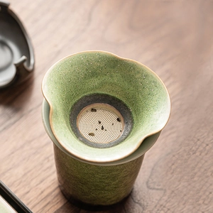 Retro ceramic tea strainer set with green spotted glaze and metal filter on wooden base