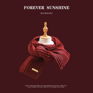 Detail of dark red knit scarf with handmade label and premium ribbed texture finish