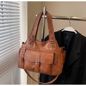 Macro detail of brown vintage faux leather tote bag with front buckle pocket and texture