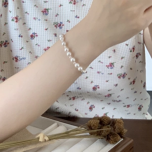 Detail of 925 sterling silver pearl bracelet worn by model showing elegant texture