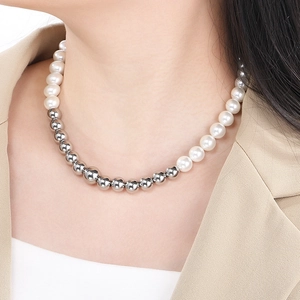 Dettaglio della collana metà perle e metà sfere d'argento indossata con un blazer beige