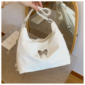 Close-up of white PU leather crossbody bag with silver butterfly metal ornament detail