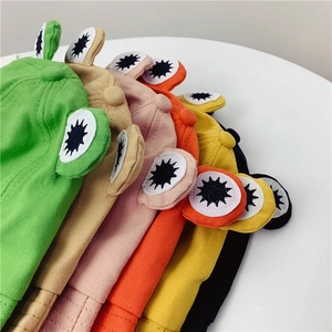 Detailed view of colorful frog eye bucket hats in green, beige, pink, and orange fabric
