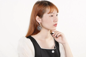 Side view of model wearing silver multi-circle earrings with a central butterfly design