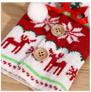 Close-up of Christmas knitted wine bottle cover with elk pattern and wooden button