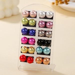 Set of 12 pairs of colorful faux pearl stud earrings on a transparent acrylic display stand