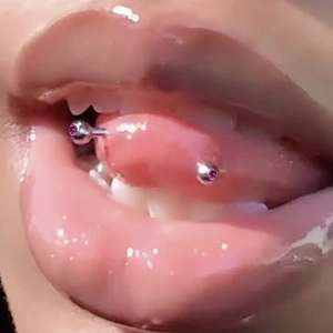 Surgical stainless steel tongue ring with pink acrylic beads shown on a model