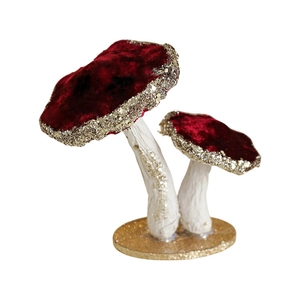 Deep red velvet mushroom ornament with gold glitter accents on a white base for Christmas