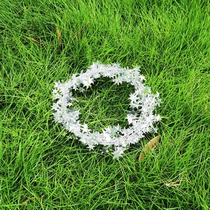 Shiny silver star garland decorations on green grass for Christmas party festive ornaments