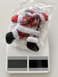 Detail showing the exact weight of 13.6g for a plush Christmas snowman ornament hanging