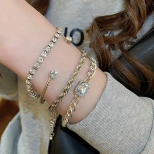 Détail d'un ensemble de quatre bracelets argentés avec cristaux portés au poignet