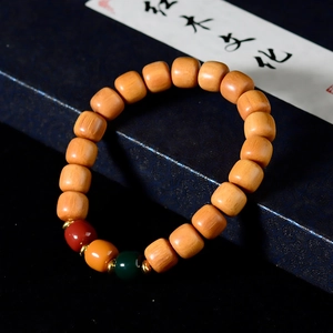 Detailed view of yellow sandalwood beads with colorful accents and gold spacers