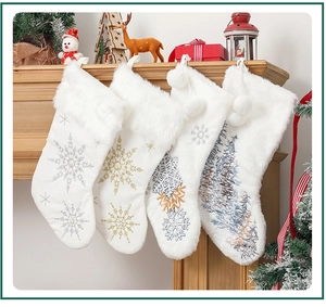 Detail view of 4 white plush Christmas stockings with silver and gold snowflake embroidery