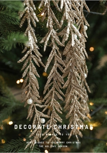 Detail of golden glitter pine branch with white pearls on a decorated Christmas tree