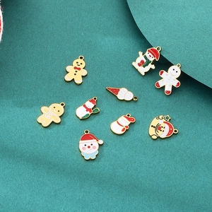 Flat lay of colorful Christmas DIY charms featuring snowman and Santa enamel pendants