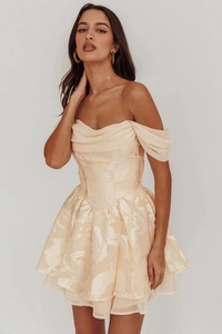Close-up of champagne gold floral jacquard texture and ruffle details on the bustier dress