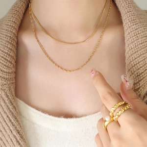 Gold double layered snake chain necklace and pearl ring set on female model