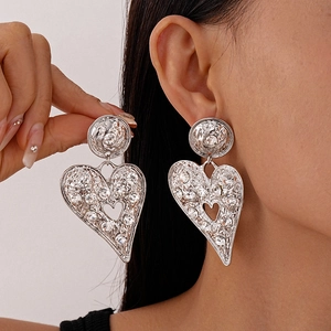 Exaggerated silver heart earrings with sparkling rhinestones for a bold geometric look