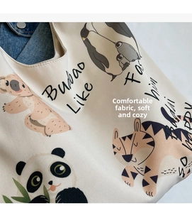 Detail of beige canvas tote bag featuring cute cartoon animal illustrations and printing