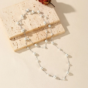 Elegant S925 sterling silver pearl long necklace layered on beige stone with dried rose
