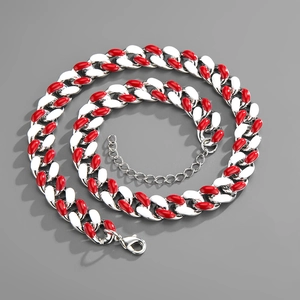 Close-up of silver and red enamel Cuban chain link necklace with lobster clasp detail