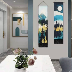 Artistic gold mountain and moon tapestries with black tassels hanging on a wall