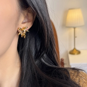 18K gold plated flower stud earrings with tiger eye and pearls on a female model