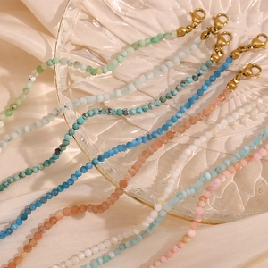 Macro shot of colorful natural stones and 18K gold-plated lobster clasp on beads