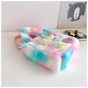 Close-up of plush rainbow unicorn bag with sequins heart and soft faux fur texture