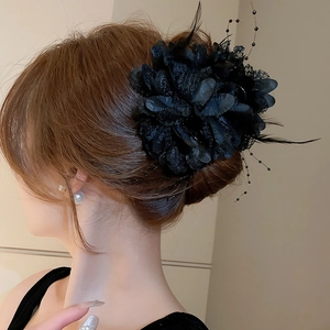 Detailed back view of a black flower hair claw with elegant lace and feather accents
