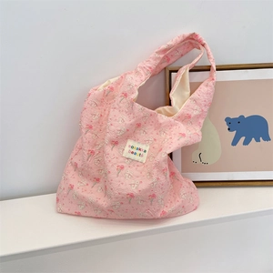 Pink quilted tote bag with cute rabbit and flower print on white surface