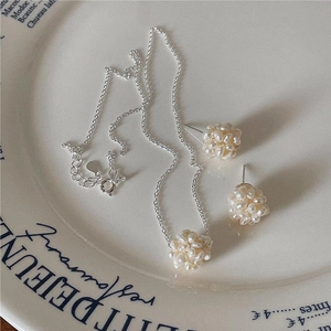 Detailed view of silver pearl jewelry set featuring woven cluster pendant and matching studs