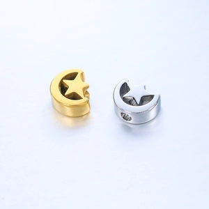 Macro view of mirror polished stainless steel moon beads with star cutouts in gold and silver