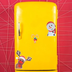 Magnetic Christmas decals featuring snowman and reindeer on a vintage yellow fridge