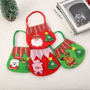 Vue à plat de quatre sacs cadeaux de Noël en feutre avec Père Noël, ours, bonhomme et renne