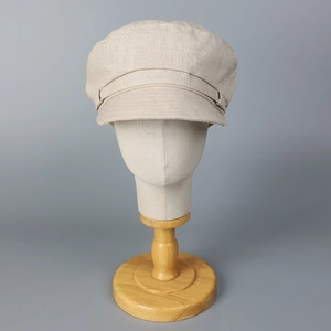Vue détaillée de la texture naturelle en lin-coton et du bouton de la casquette beige