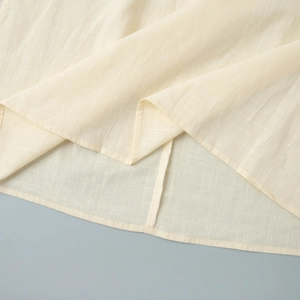 Zoom sur l'ourlet de robe en coton beige avec des coutures à double fil de haute qualité