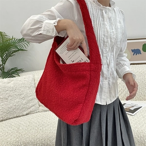 Detail of red fuzzy tote bag showing large capacity for books and soft bouclé texture