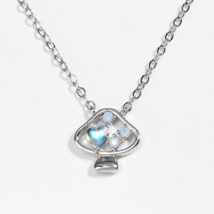 Primo piano di una collana con ciondolo a fungo argentato e intarsio in opale scintillante