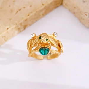 Macro shot of gold frog ring with heart green stone and adjustable band detail