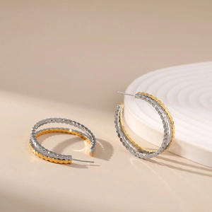 Modern two-tone gold and silver C-shaped hoop earrings with embossed dotted texture