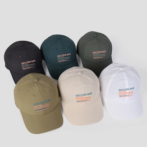 Flat lay of nylon baseball caps in six colors showing quick-dry fabric and letter print
