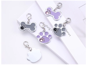 Detailed view of bone and paw print pet ID tags with enamel finish and lobster clasp