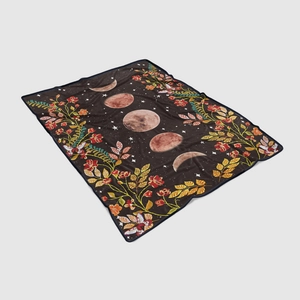 Detail of bohemian black flannel blanket with moon phases and vibrant floral patterns