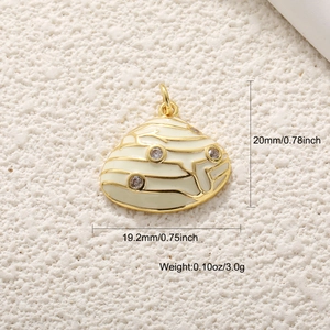 Macro view of a gold-plated seashell pendant with beige enamel and crystals showing dimensions