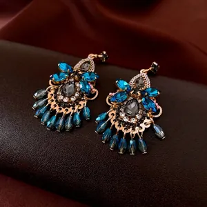 Vintage luxury earrings with blue crystal gemstones and beaded tassels in a gold setting