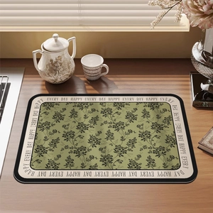 Olive green floral kitchen drying mat on a wooden table with elegant shadows