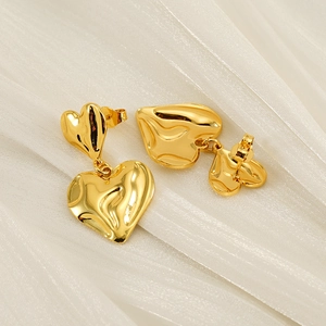 Minimalist double layer heart earrings with gold lava texture on white silk background