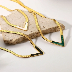 Three elegant gold V-shaped pendant necklaces with white, black, and green stone inlays