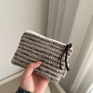 Close-up of woven fabric coin purse with monochrome texture and zipper detail